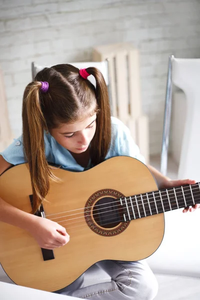 girl enjoys playing the guitar