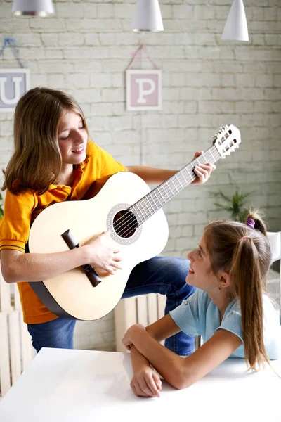 Niños aprenden a tocar la guitarra —  Fotos de Stock