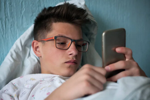 悲伤的青少年使用手机 免版税图库照片