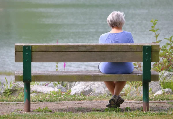 Senior kobieta na ławce w parku — Zdjęcie stockowe