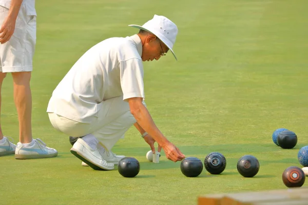 Trávník Bowler opatření míč na Jack — Stock fotografie