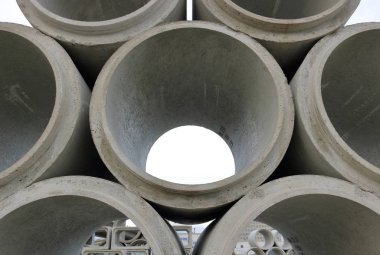 Close on a stack of cement sewer parts that will be assembled to create new sewer lines.  clipart