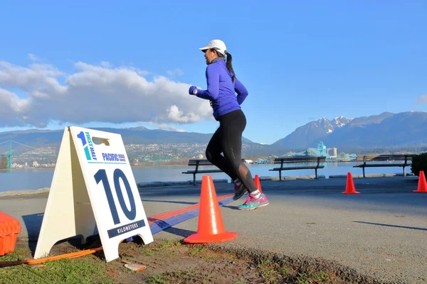 一个赛跑者横跨10公里标记在每年太平洋路赛跑者半马拉松在温哥华 加拿大在2018年2月11日 — 图库照片