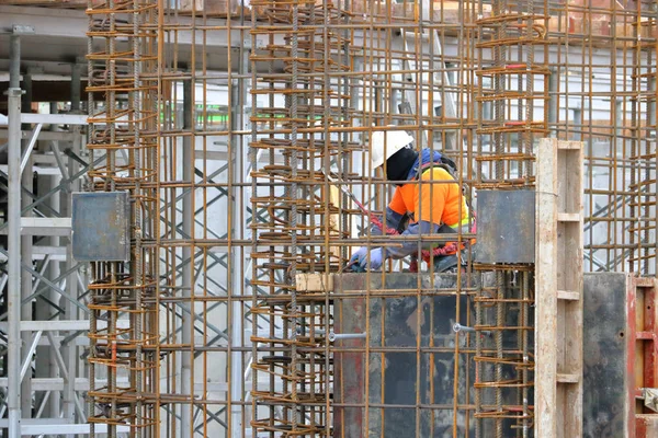 Ein Bauarbeiter Umgeben Von Bewehrungsstangen Wickelt Oder Bindet Die Metallbewehrung — Stockfoto