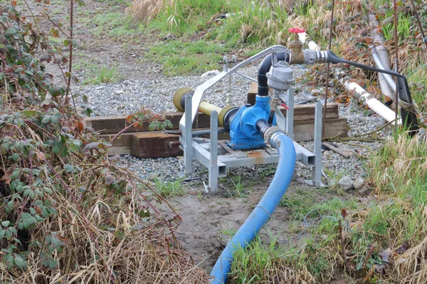 关闭一个用来从沟渠里取水灌溉农作物的小型水泵 — 图库照片