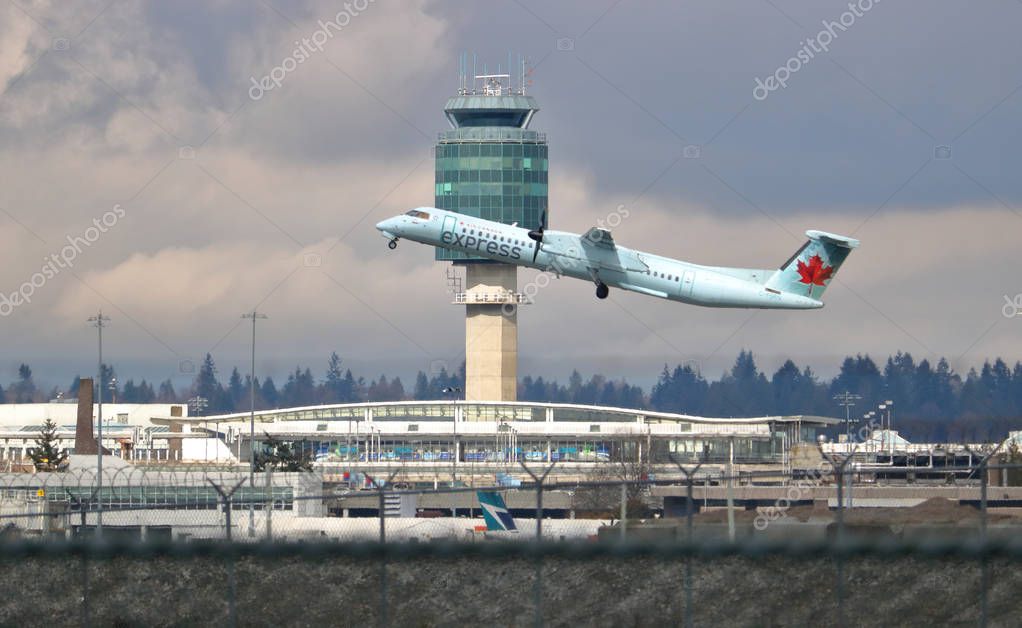 Taking off while passing the Vancouver International Airport control tower (YVR) on March 24, 2018, Air Canada Express is a regional commercial airliner.