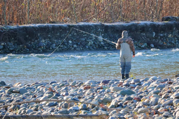 Single Fisherman Stands Rocky Shoreline Fast Moving River His Rod — ストック写真