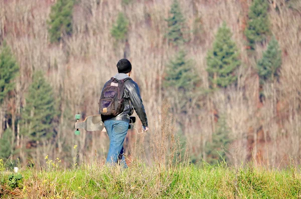Dağlık Bir Bölgede Kaykayıyla Yürüyen Bir Gencin Alçak Geniş Açılı — Stok fotoğraf