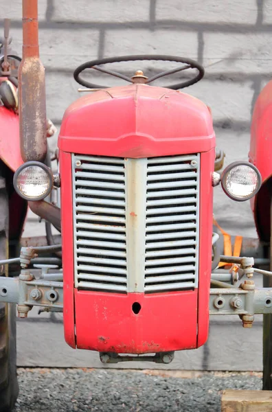 老式红色拖拉机前烤架和前照灯的垂直近景 — 图库照片