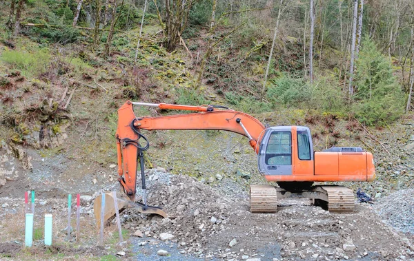 停放在森林前的建筑用铲子的广角图 该铲子正在被清理以用于住宅开发 — 图库照片