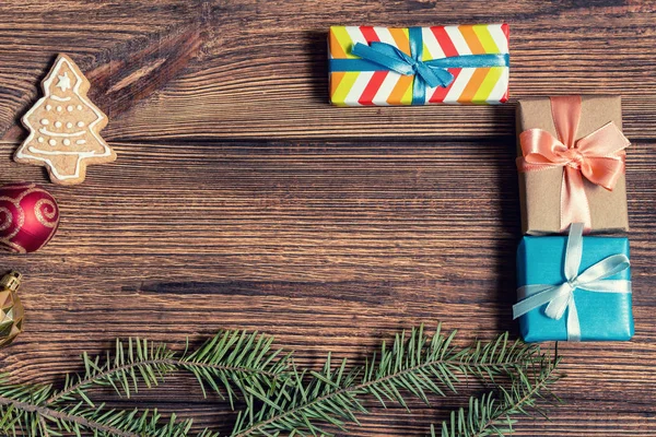 Colorful gift boxes cookies, fir, spruce, branches on a dark wooden background. The concept of preparing for the holidays New Year and Christmas.