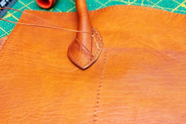Sewing brown leather bag. Leather craft process.