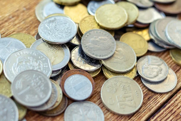 coins old rusty brass euro Seychelles Bulgaria China Germany pile pack heap stack on a wooden background finance economy investment savings concept mock up selective focus close up