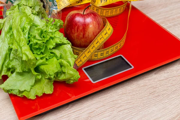 digital electronic scale with measuring tape, lettuce. Apple, diet, slimming concept.