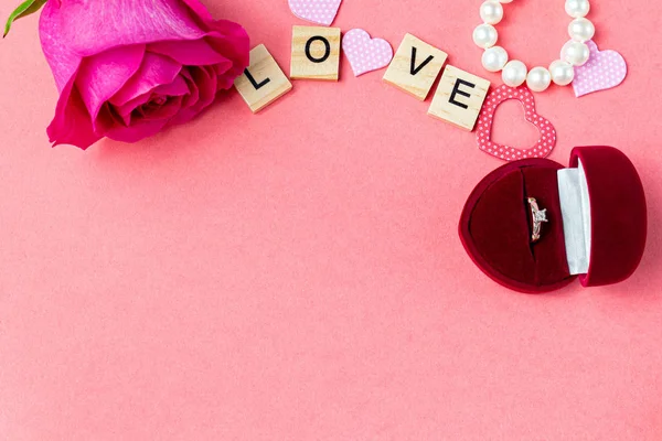 Word love with hearts and flower on the pink background. Valentine gift card background
