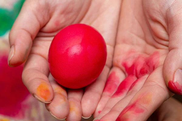 red egg in hands for the Easter