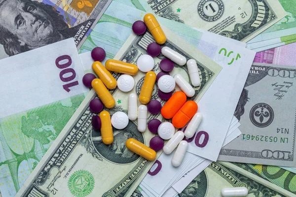 colorful medicine tablets pills on the money background. Pandemic economic crisis