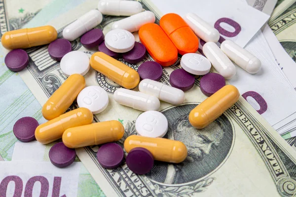 colorful medicine tablets pills on the money background. Pandemic economic crisis
