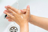 Kisgyerek, a gyerek kezet mos a csap alatt a mosogatóban.