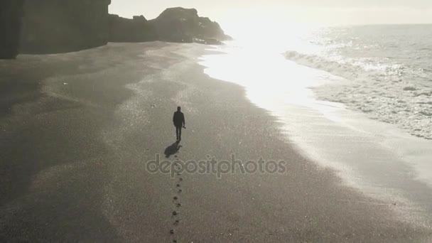 Man lämnar bakom fotspår på stranden — Stockvideo