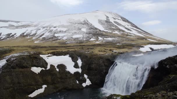 Islandský vodopád proti sněhu krytá Hora — Stock video