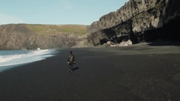 Muž s kamerou chůze na pláž — Stock video