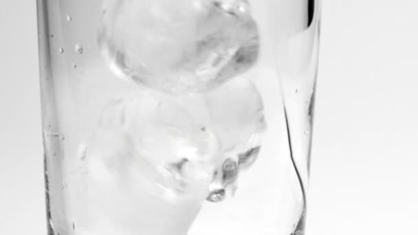 Лед падает в стекло — стоковое видео
