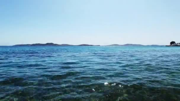 Drone volando sobre el agua azul con una vista de las siluetas de la cordillera sobre la cabeza — Vídeo de stock