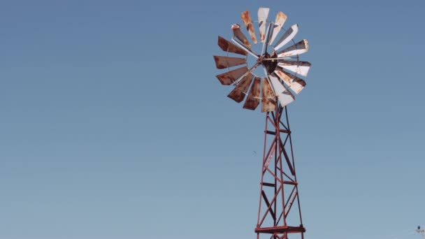 Panorámica media disparada desde una vieja bomba de viento oxidado que sube al cielo — Vídeos de Stock