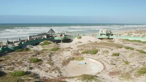 Πετώντας πάνω από εγκαταλελειμμένο Water Park Αντιμετωπίζοντας τον ωκεανό με κύματα συντρίβοντας την παραλία — Αρχείο Βίντεο