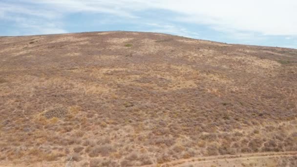 Drone volando hacia la cima de una colina revelando un pueblo en Sudáfrica — Vídeo de stock
