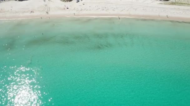 Luftaufnahme eines Strandes mit Touristen, die am Ufer spazieren und schwimmen — Stockvideo