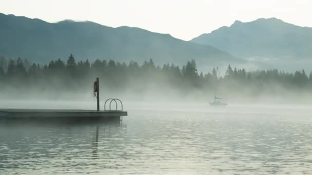 Dolly Shot von einem Boot und einem Sprungbrett inmitten eines nebligen Sees — Stockvideo