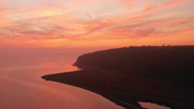 Sahil ve Durgun Su Üzerinde Gün Doğumu Renkli Gökyüzü Görünümü