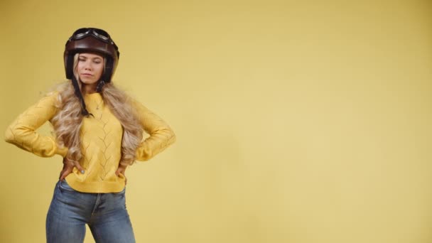Женщина позирует в шлеме на голове, когда ветер дует ей в волосы — стоковое видео