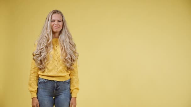 Junges, fröhliches Model mit langen lockigen Locken, die den Daumen nach oben geben — Stockvideo