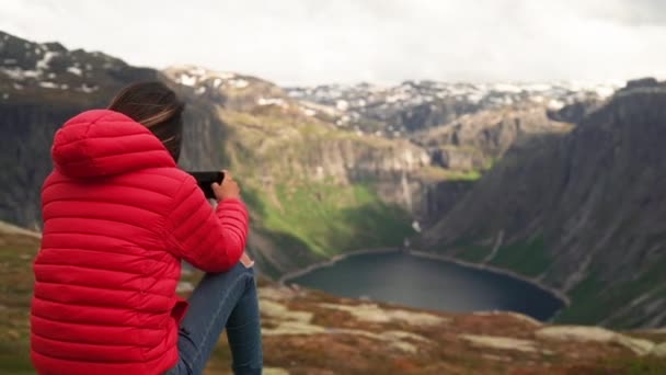 Costas de mulher vestindo um casaco vermelho ao tirar fotos com telefone — Vídeo de Stock