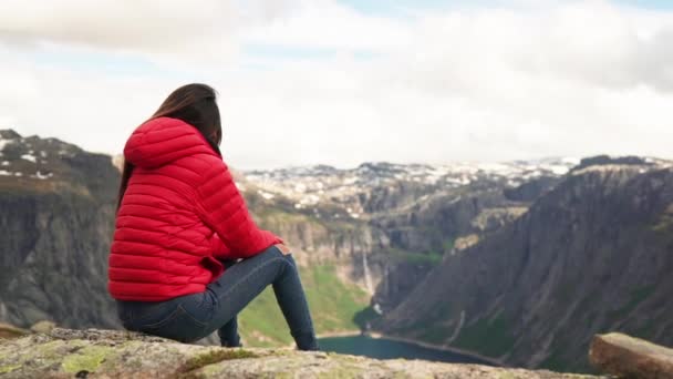 Kvinnlig vandrare sitter på toppen av ett berg med utsikt över naturen — Stockvideo