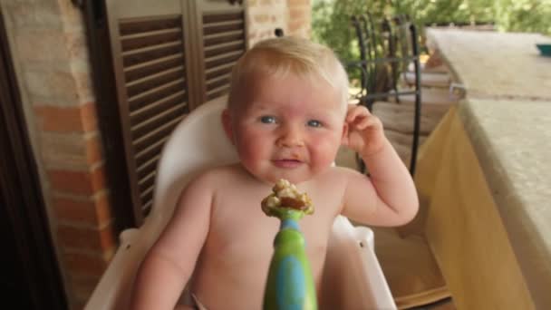 Happy Baby Boy korzystających z jego puree podczas relaksu jego wysokie krzesło — Wideo stockowe