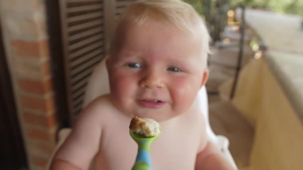 Chiusura di un simpatico bambino che mangia purea nel patio — Video Stock