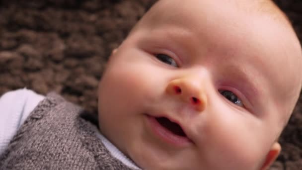 美しい赤ちゃん男の子は羊の毛のウールの肌に横たわっている — ストック動画