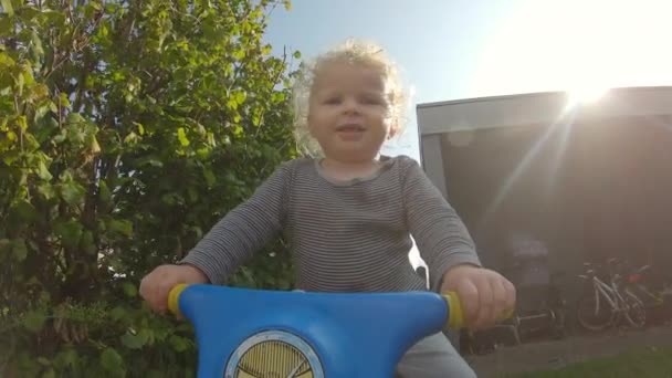 Arka bahçede bisiklete binen güçlü iradeli bir çocuğun görüntüsü. — Stok video