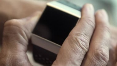 Bir adamın bileğindeki Fitbit İyonik Fitness Takipçisinin Yakın Çekimi
