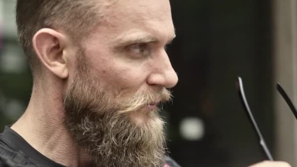 Closeup Shot of a Hipster Guy Put on his Colored Sunglasses with a Smile — Stock video