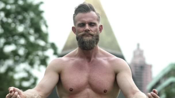 Бородач без рубашки с закрытыми глазами на позицию йоги — стоковое видео