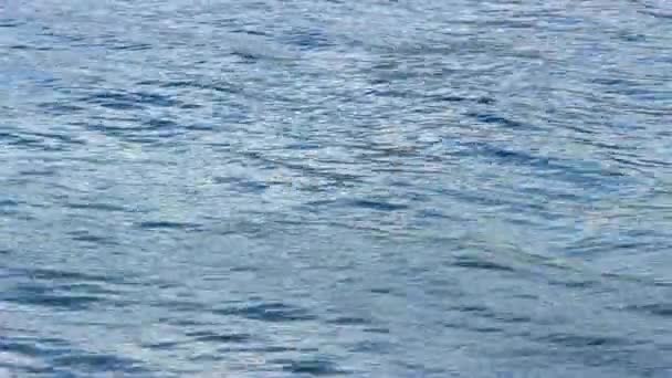 Fermer Vue d'un ondulation d'eau perturbée et d'une lumière réfléchissante 