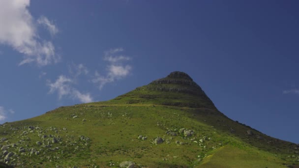 Vista de una cima de montaña contra el cielo azul claro con siluetas de nubes — Vídeos de Stock