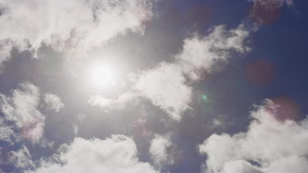 Nagranie ruchu chmur ukrywającego światło słoneczne przed błękitnym niebem — Wideo stockowe