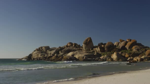 Shot medio di una spiaggia ondulata sulla spiaggia di masso, Sud Africa — Video Stock