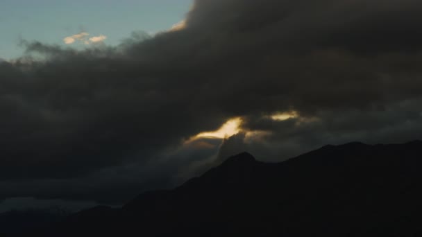 Sky vid solnedgången Täckt av mörka moln med berg i bakgrunden — Stockvideo